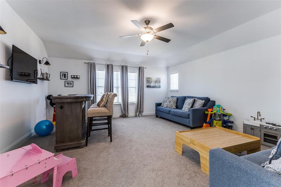 Carpeted game room featuring ceiling fan