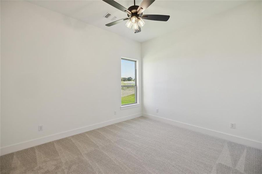 Spare room featuring ceiling fan and light carpet