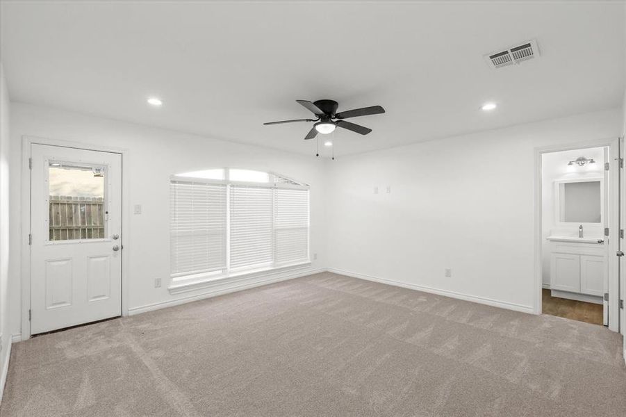 Carpeted spare room featuring ceiling fan