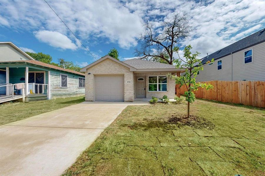 View of front of home with a front yard and a garage