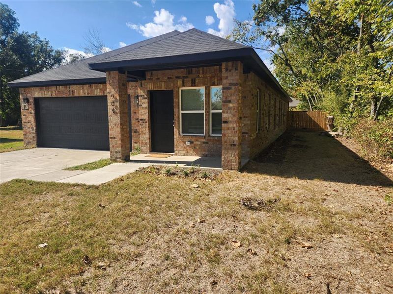 View of front facade featuring a front yard and a garage