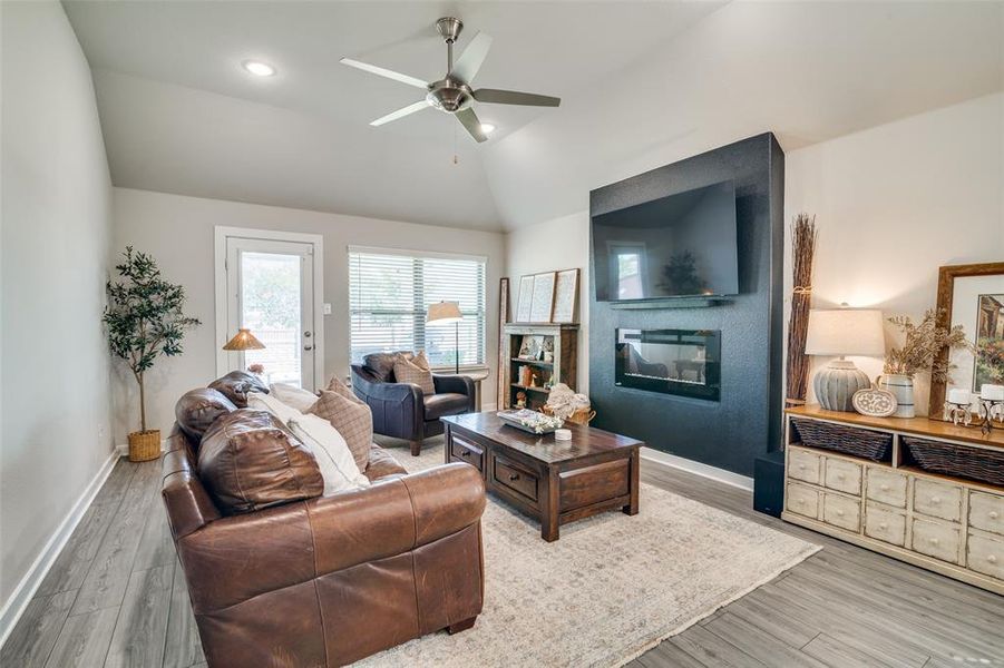 Living room featuring wood-type flooring, lofted ceiling, and ceiling fan