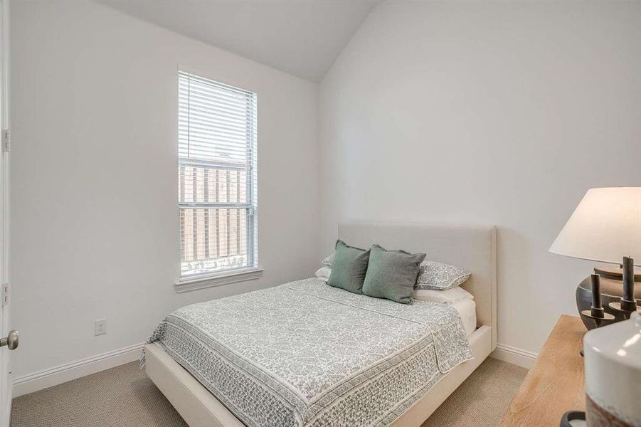 Carpeted bedroom featuring lofted ceiling