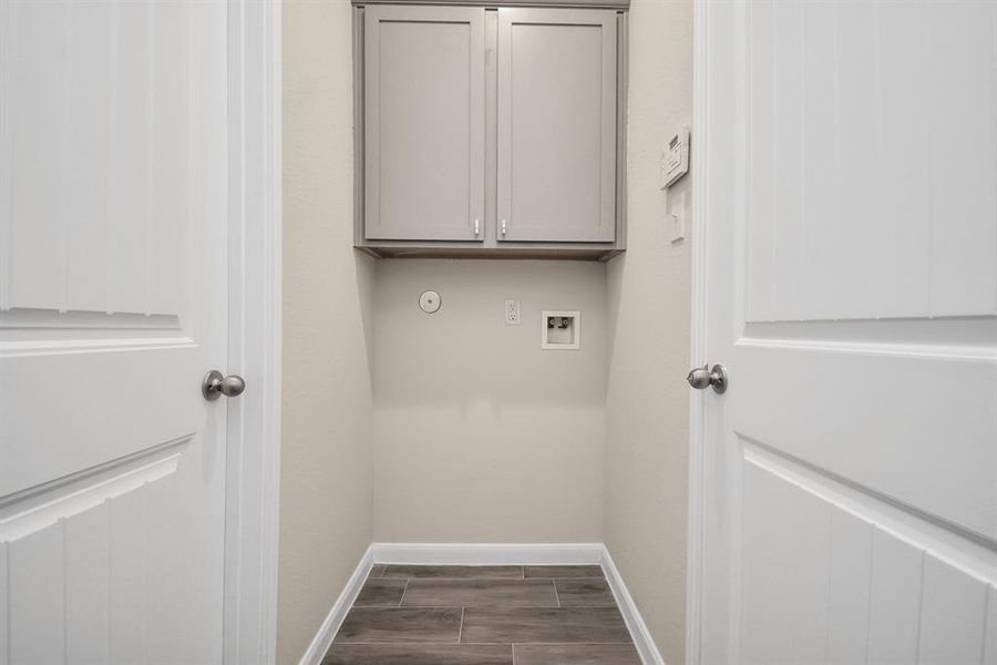 This dedicated laundry room offers the perfect canvas to create your dream laundry space!  Generous cabinetry provides ample storage for essentials, while the room's layout easily accommodates your choice of side-by-side or stackable washer and dryer units. **This image is from another Saratoga Home with similar floor plan and finishes, not the Brittany floorplan.**