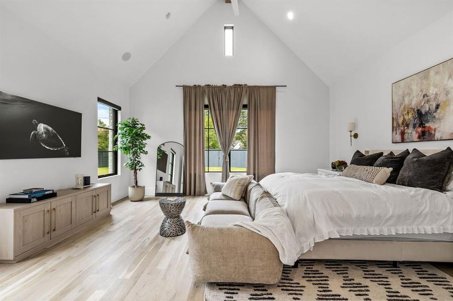 Bedroom featuring light hardwood / wood-style flooring, high vaulted ceiling, and beam ceiling