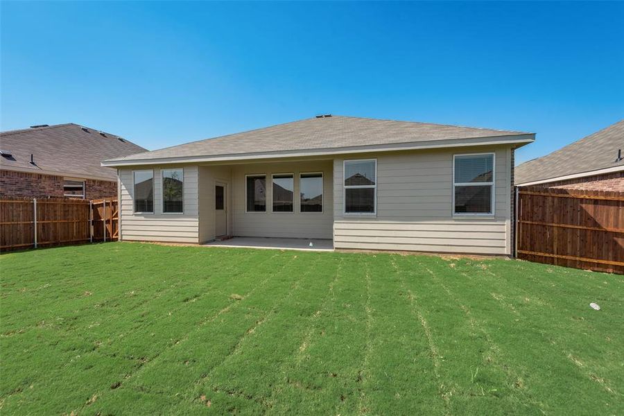 Rear view of house featuring a patio and a yard