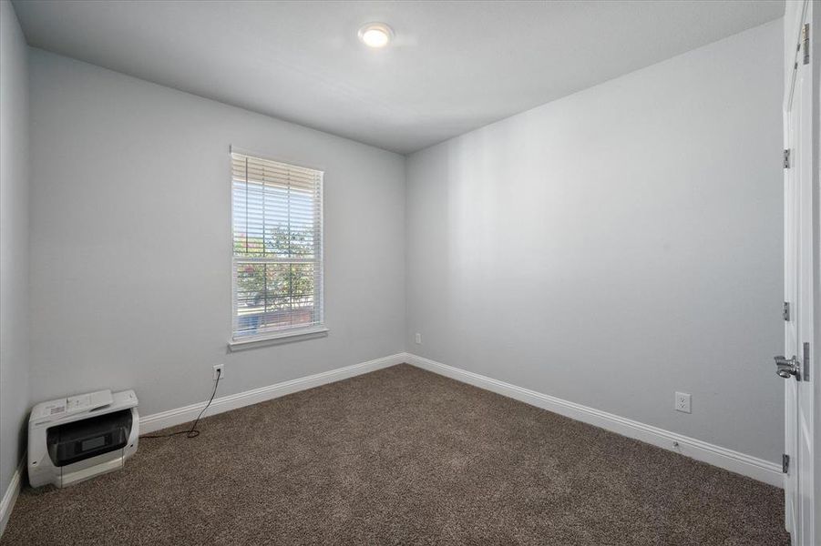 Downstairs first bedroom, carpeted empty room