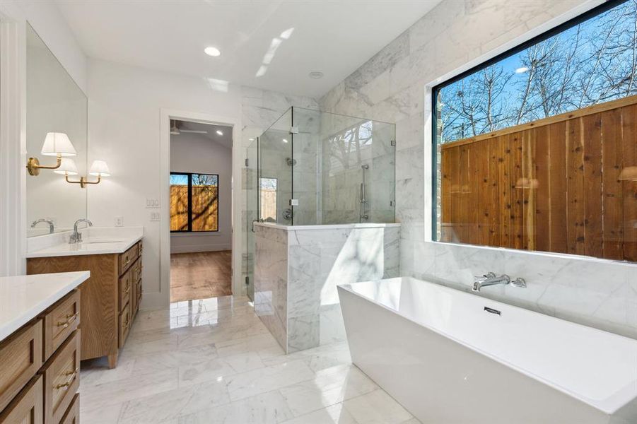 Bathroom featuring shower with separate bathtub, vaulted ceiling, and vanity