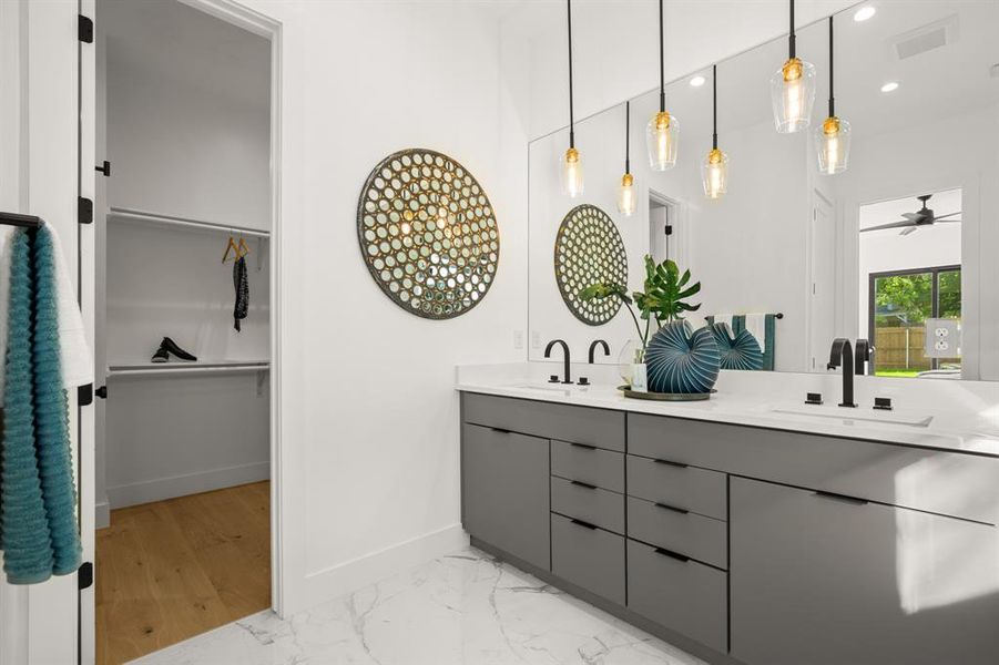 The gorgeous dual vanity comes complete with a quartz countertops and custom contemporary cabinetry with stylish pendant lighting and designer finishes.