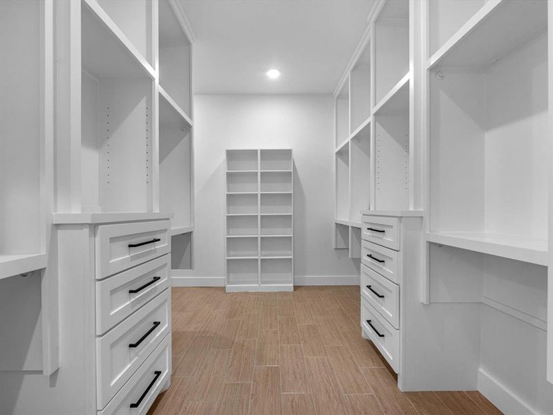 There is plenty of space in this custom primary walk in closet featuring drawers, shelving, and more space to add a vanity, safe, or more closet space.