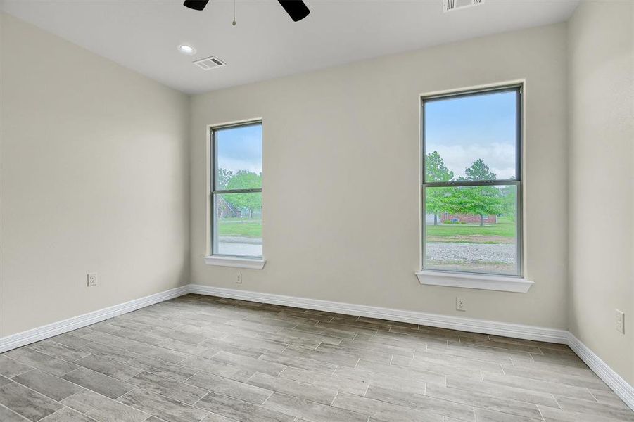 Bedroom featuring plenty of natural light, Tile Plank flooring, and ceiling fan