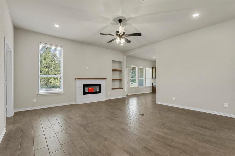 Unfurnished living room featuring hardwood / wood-style flooring and ceiling fan