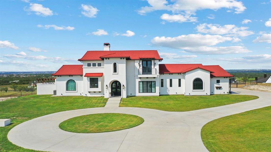 Mediterranean / spanish house with a balcony and a front yard