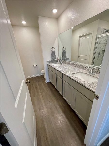 Double sinks and granite counters are a must in this primary bathroom.