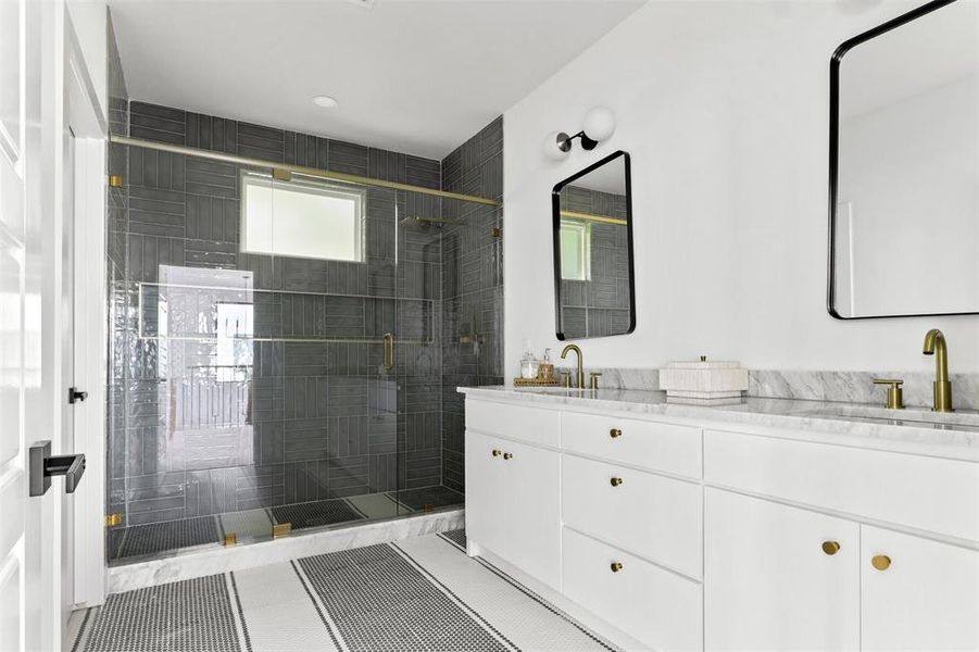 Bathroom featuring a shower with door, vanity, and tile patterned flooring