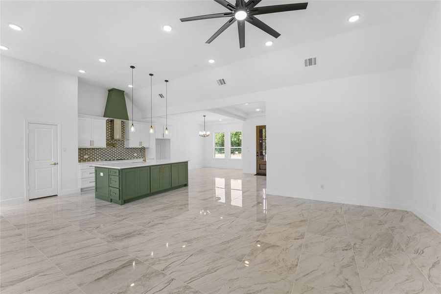 Kitchen with a center island, white cabinetry, hanging light fixtures, green cabinets, and ceiling fan with notable chandelier