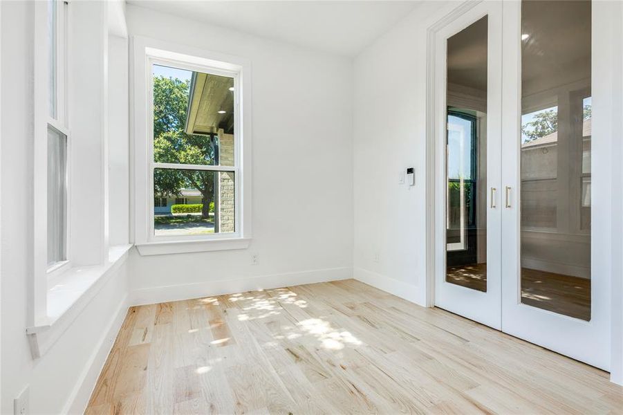 Unfurnished room featuring french doors and light wood-type flooring