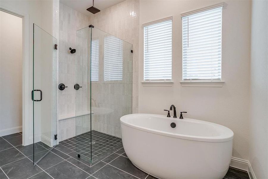 Bathroom with tile patterned floors, shower with separate bathtub, and a wealth of natural light
