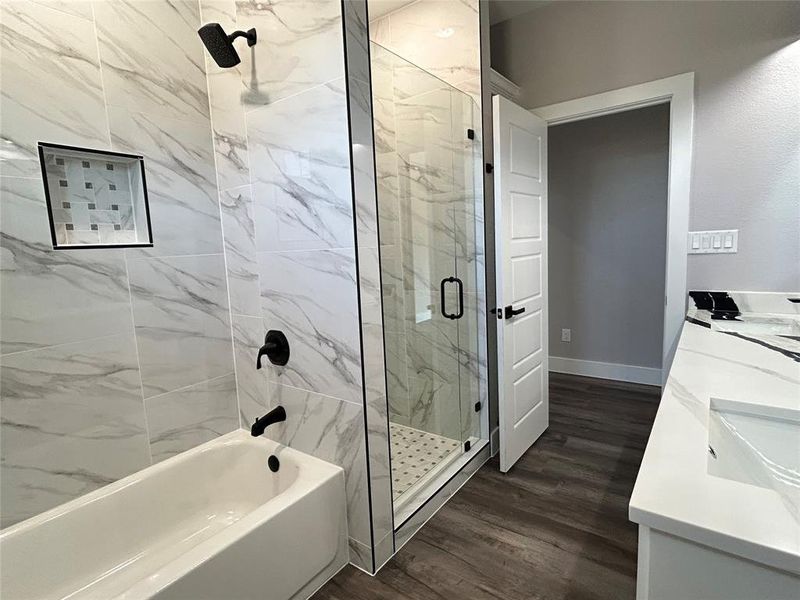 Bathroom featuring wood-type flooring, vanity, and plus walk in shower