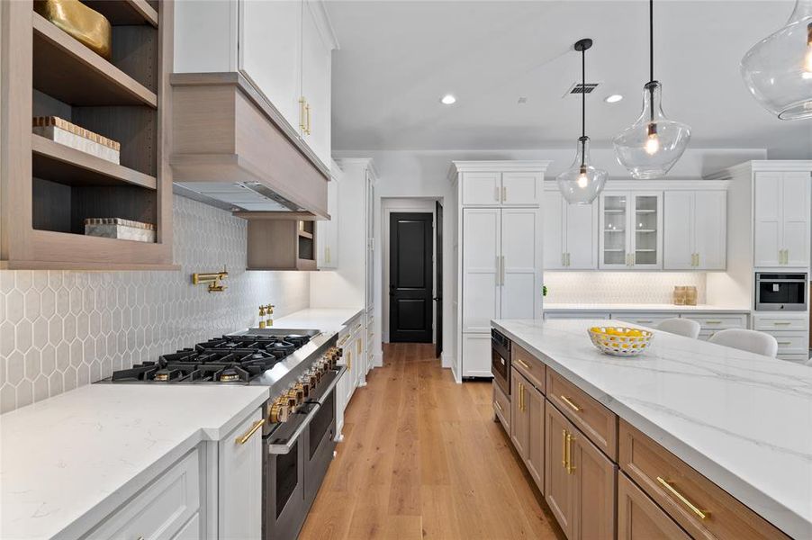 Stunning accent golden  calacatta island countertop perfectly matches the cabinet wood tone and the gorgeous wood floors.
