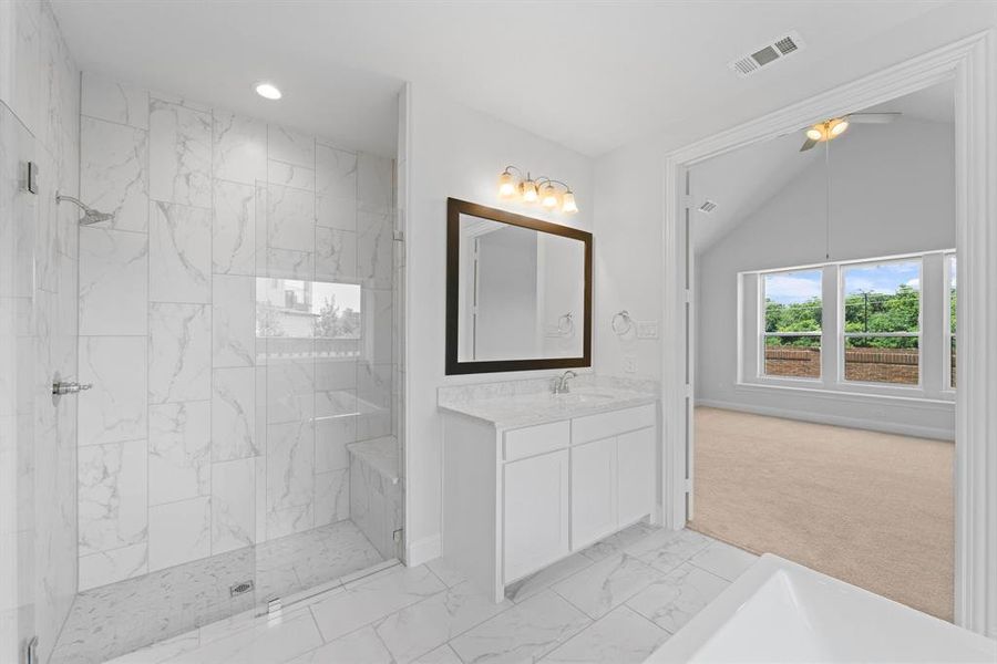 Bathroom featuring tiled shower, lofted ceiling, ceiling fan, tile floors, and vanity