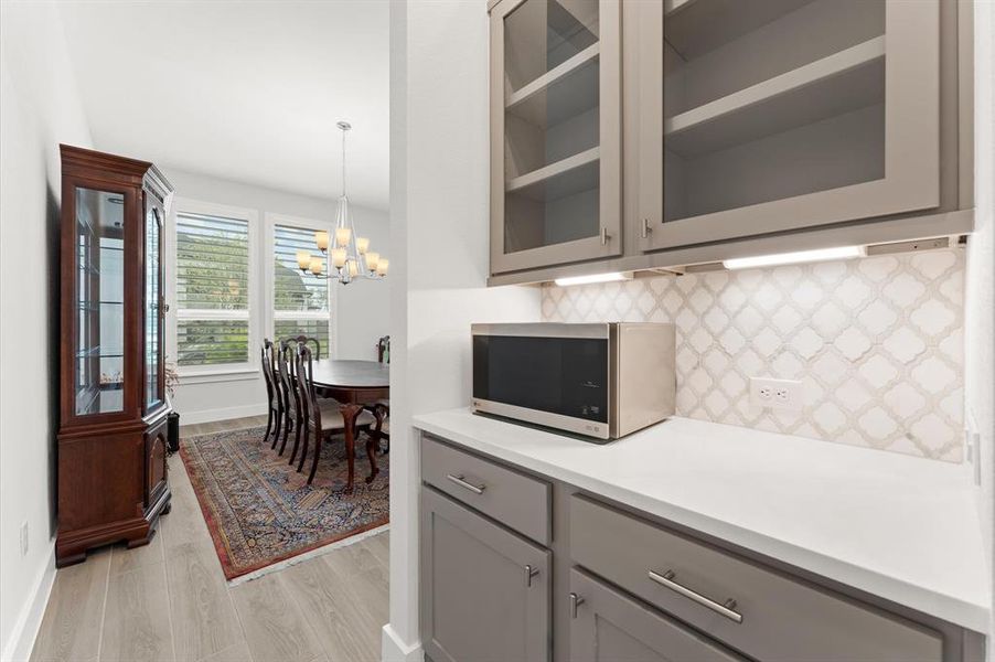 The butler’s pantry offers both convenience and sophistication, seamlessly connecting the dining room to the kitchen. It features custom cabinetry for extra storage and countertops ideal for staging meals or drinks during gatherings.