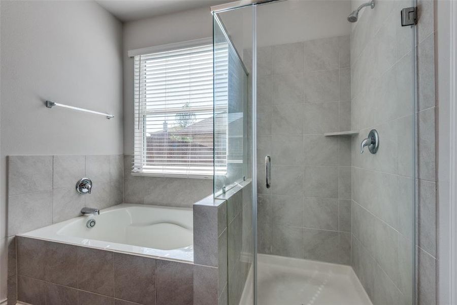 Bathroom featuring plus walk in shower and a wealth of natural light