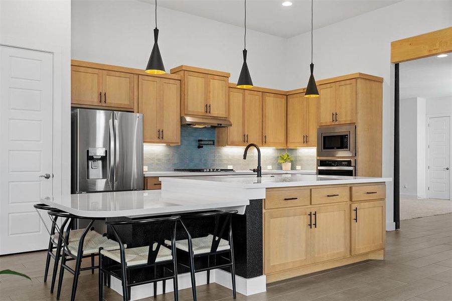 From the huge center island and extended breakfast counter to the quartz countertops, tile backsplash, and stainless appliances, this space is a chef's paradise
