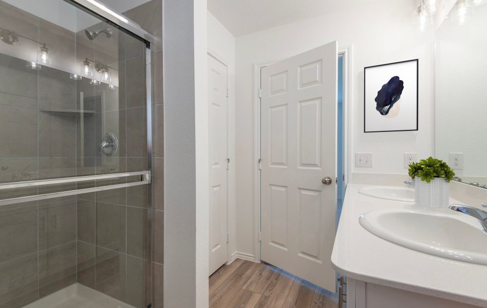 Modern owner's bath with dual vanities and a spaci