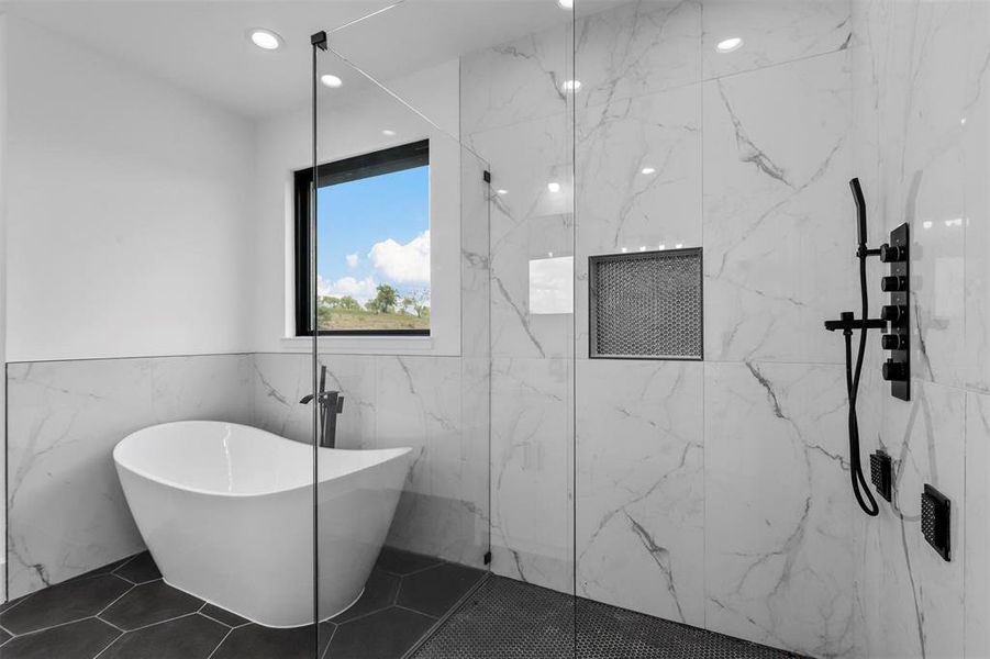 Bathroom with tile walls, tile patterned floors, and a tile shower