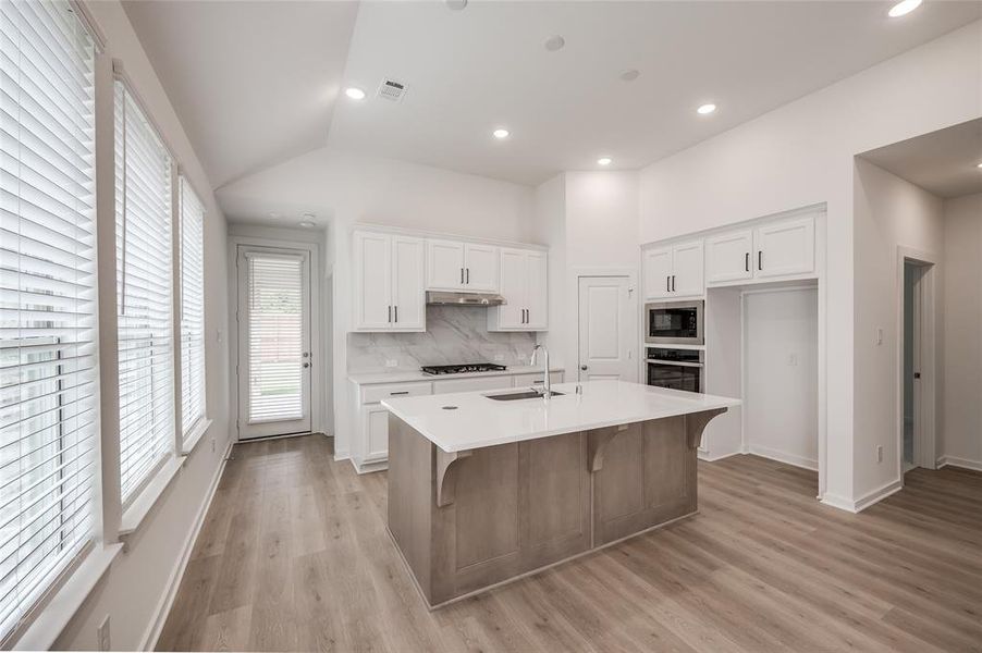 Kitchen features white cabinets.