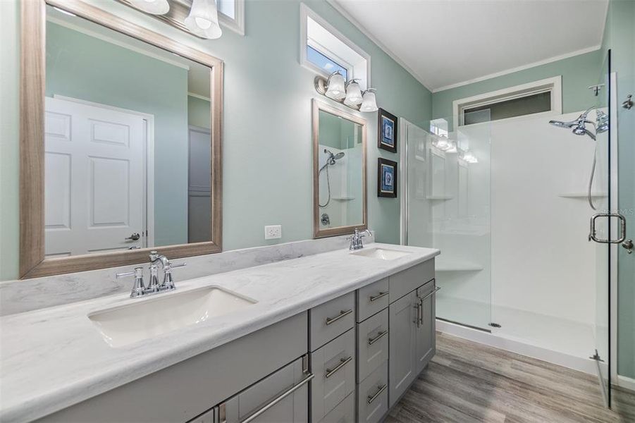 Sleek Owners retreat bath ensuite with dual undermount sinks, custom mirrors, transom windows and large shower with seat!