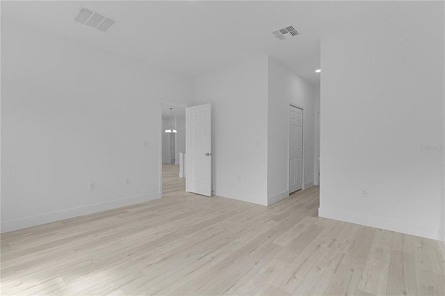 Primary bedroom looking toward entry door and double walk-in closets