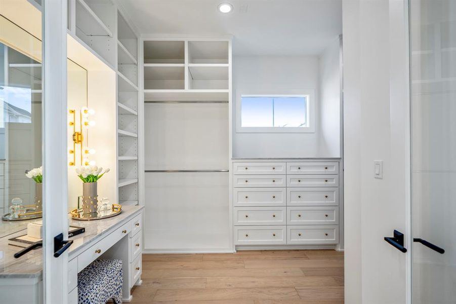Texas-sized walk-in closet with a sit down lighted vanity. Closet extends and has more built-ins just to the right of this picture.