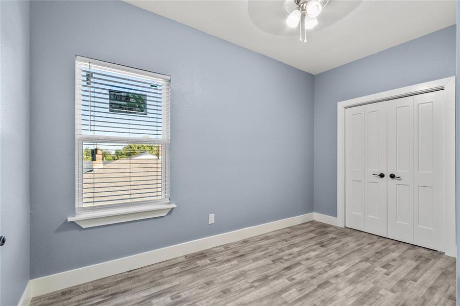 Unfurnished bedroom featuring ceiling fan, light wood-type flooring, and a closet