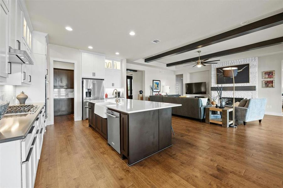 Gourmet kitchen features quartz countertops, double ovens, stainless appliances and oversized bar area.  High end lighted cabinets on the upper level and a coffee bar is next to the refrigerator.