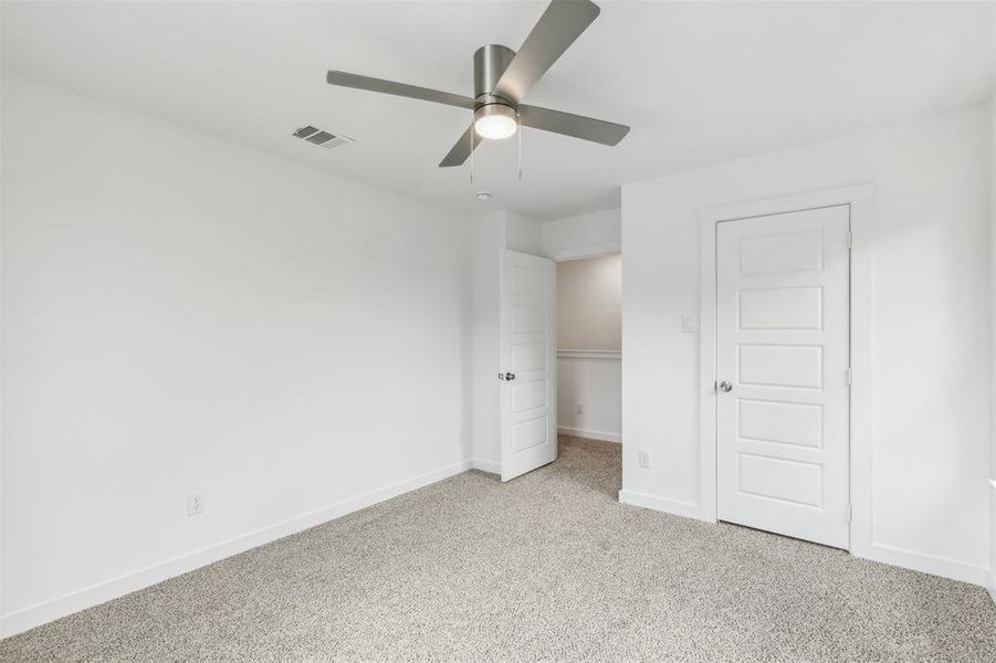Unfurnished bedroom with light colored carpet, a closet, and ceiling fan