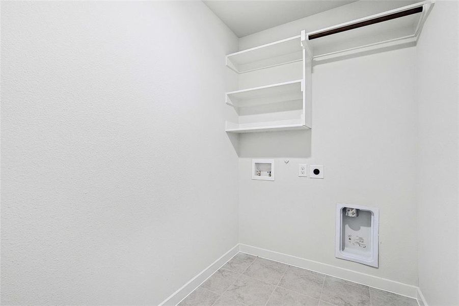 Washroom with gas dryer hookup, electric dryer hookup, light tile patterned floors, and hookup for a washing machine