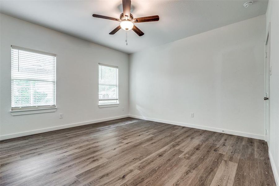 Spare room featuring ceiling fan, plenty of natural light, and hardwood / wood-style floors