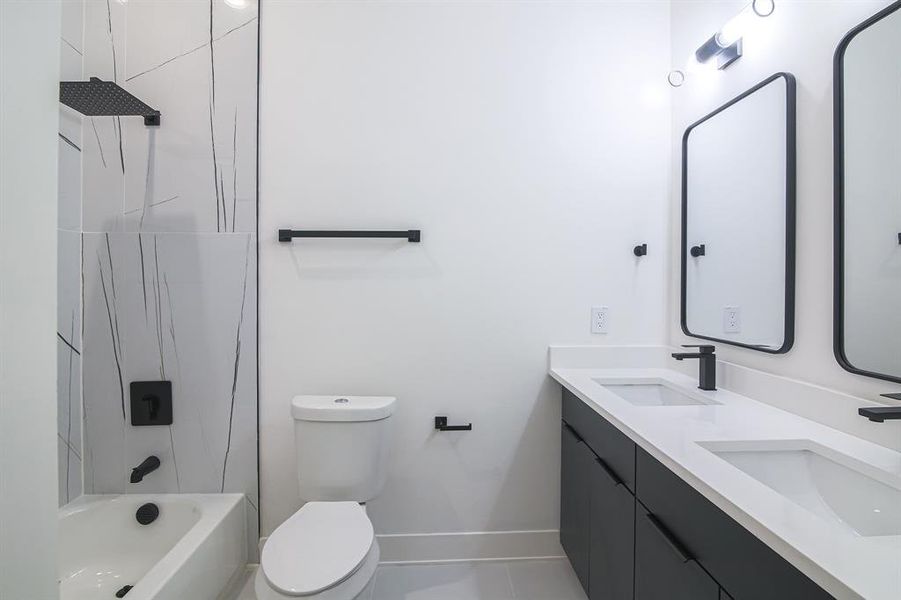 Full bathroom featuring tile patterned flooring, tiled shower / bath combo, vanity, and toilet