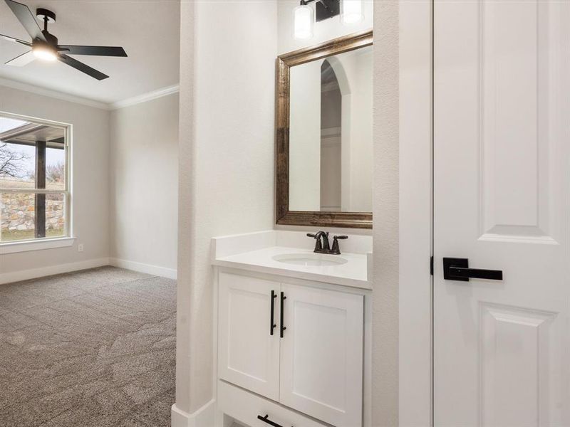 Bathroom with ornamental molding, ceiling fan, and vanity