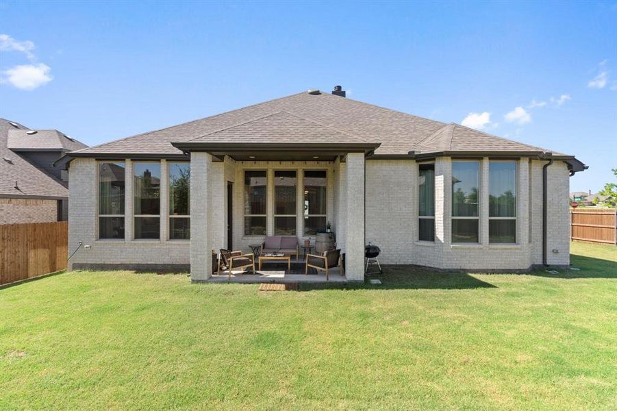 Rear view of house featuring outdoor lounge area, a yard, and a patio