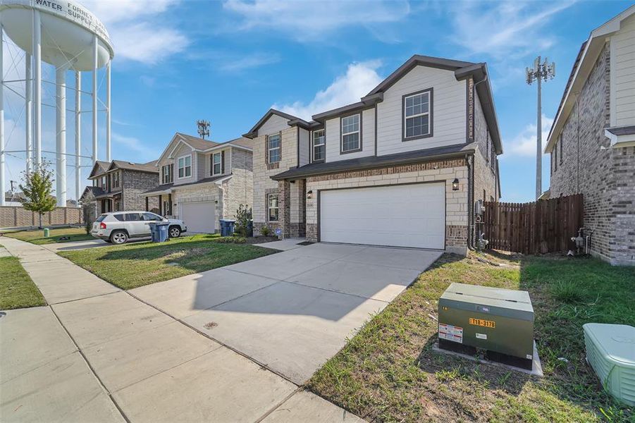 View of front property featuring a front yard and a garage