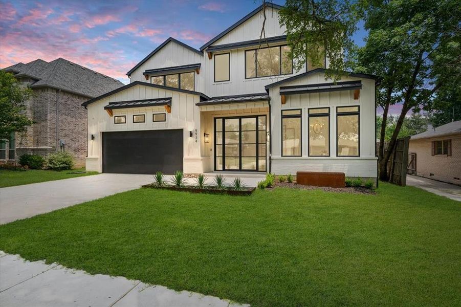 View of front of house with a garage and a yard