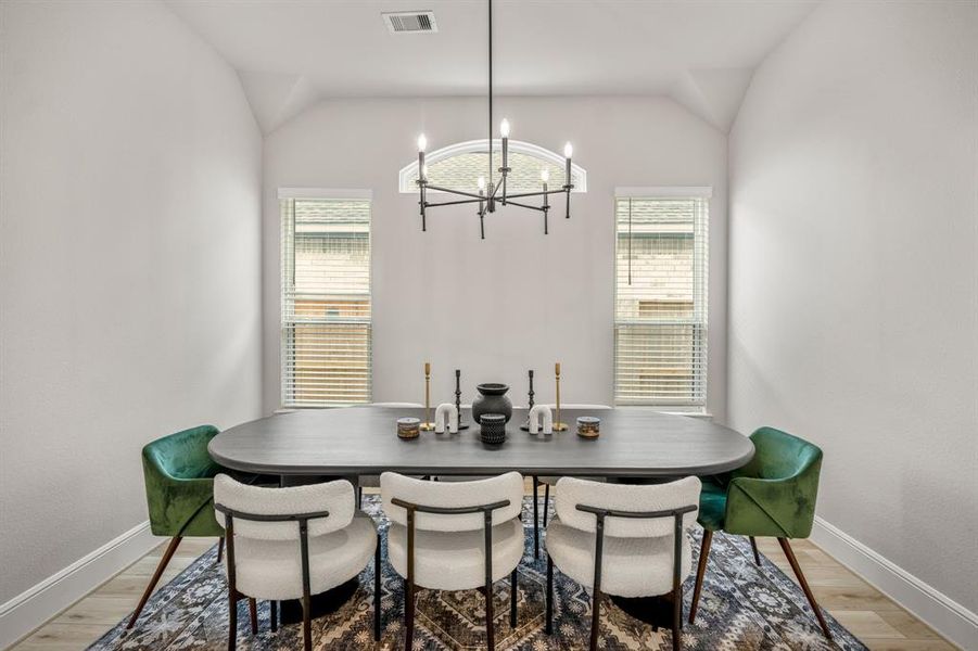 Make memories gathered around the table with your family and friends! This dining room features high ceilings, bright natural light, wood like flooring, and a modern chandelier. It connects to the kitchen and family room for easy entertaining.