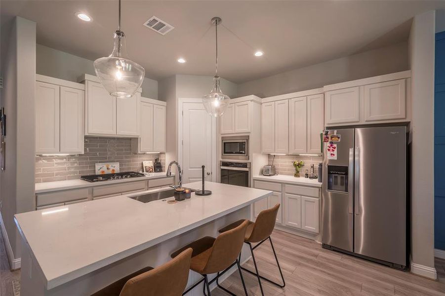 The table height island has seating for 3 with a large stainless sink.