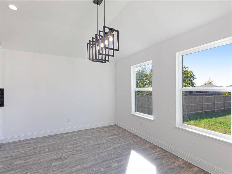 Unfurnished dining area with lofted ceiling, a chandelier, and dark wood-type flooring