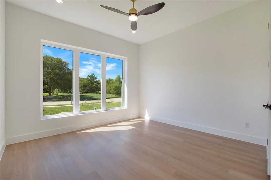 Unfurnished room with light hardwood / wood-style floors and ceiling fan