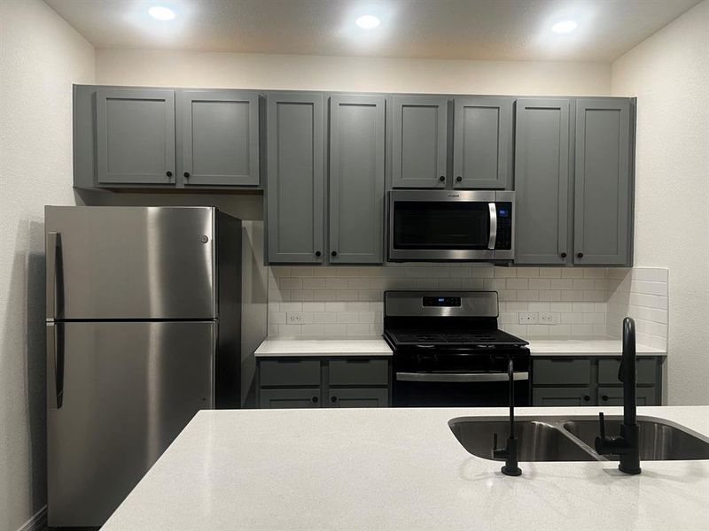 Brand new refrigerator and the modern faucet and cabinet knobs.