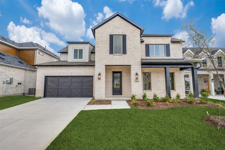 View of front of home with a front yard and a garage